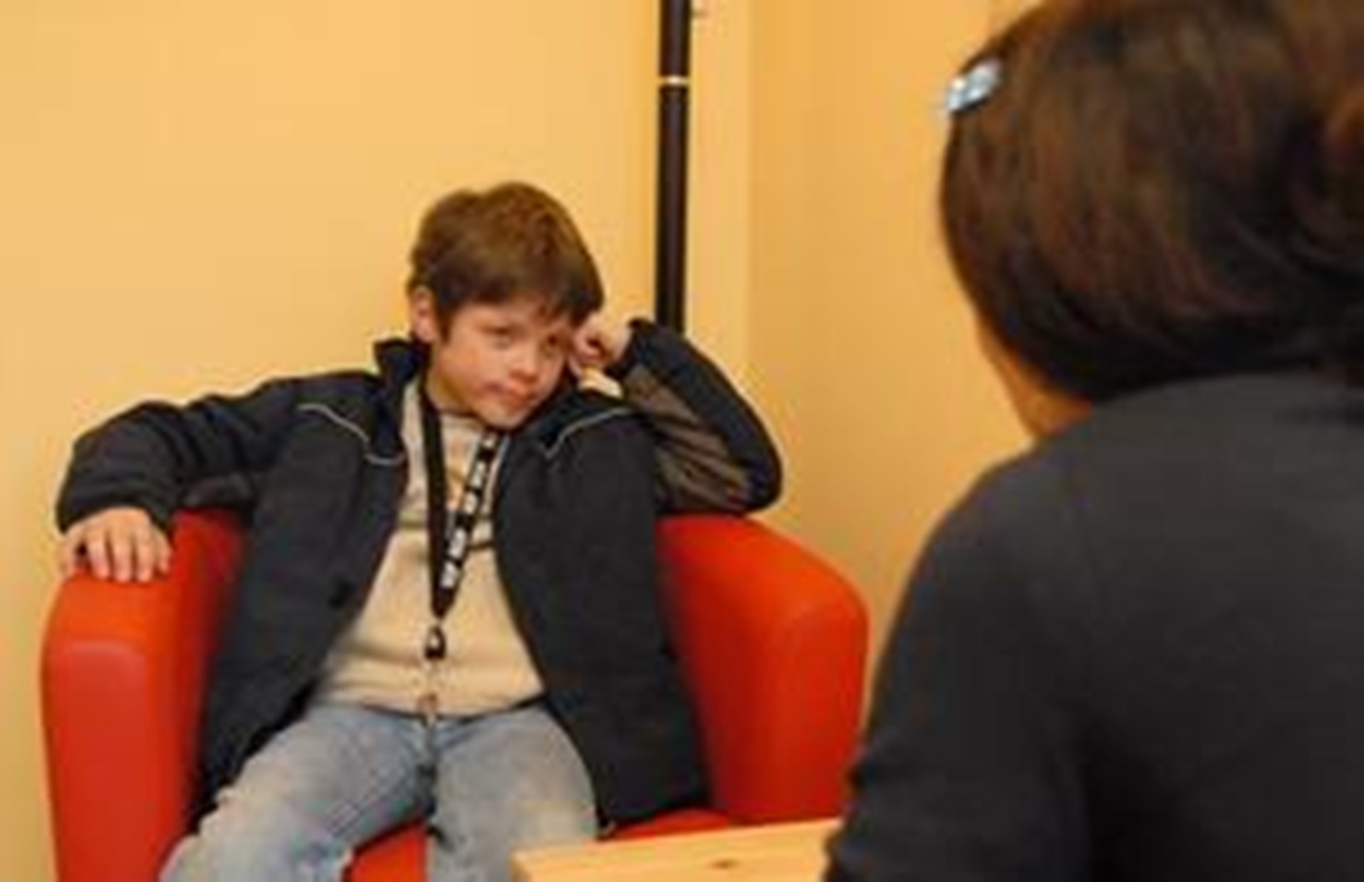 Frau und Junge, der im Sessel sitzt, im Gespräch