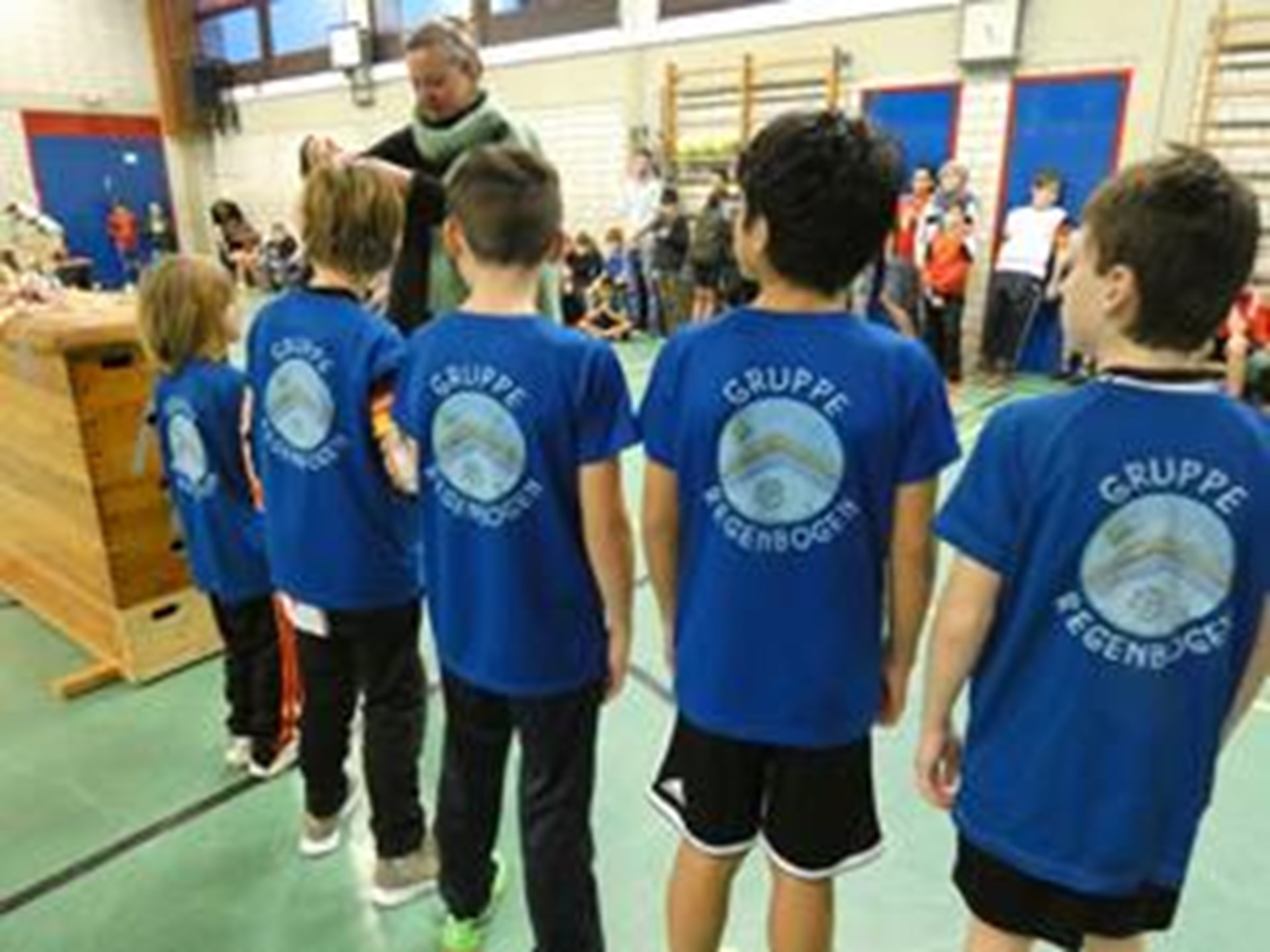 Jungenmannschaft mit blauen Trikots steht aufgereiht in der Halle.